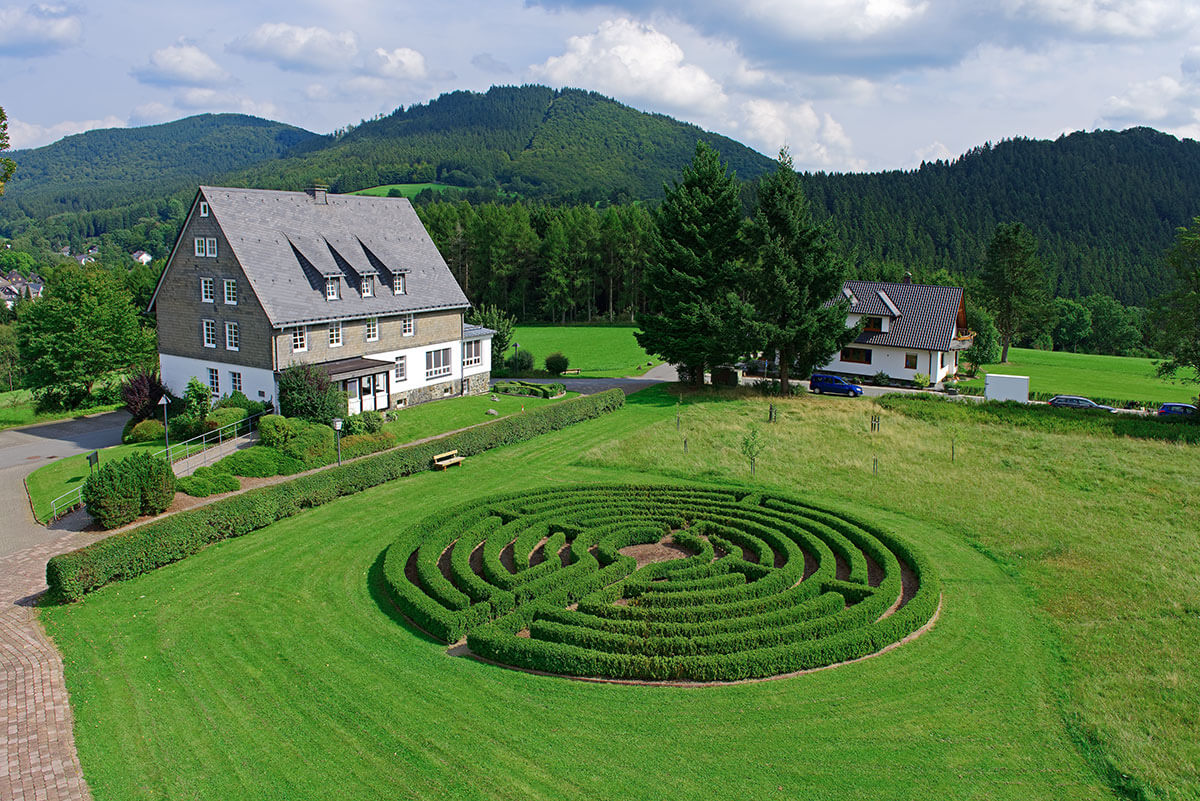 Heckenlabyrinth mit Anlage im Hintergrund