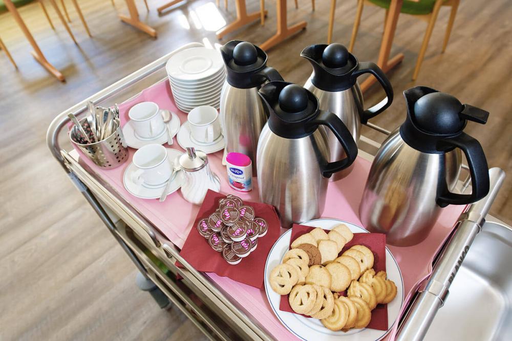 Servierwagen mit Kaffeekannen und Gebäck