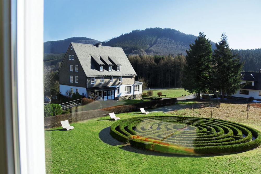 Blick auf das Heckenlabyrinth aus einem der Gebäude