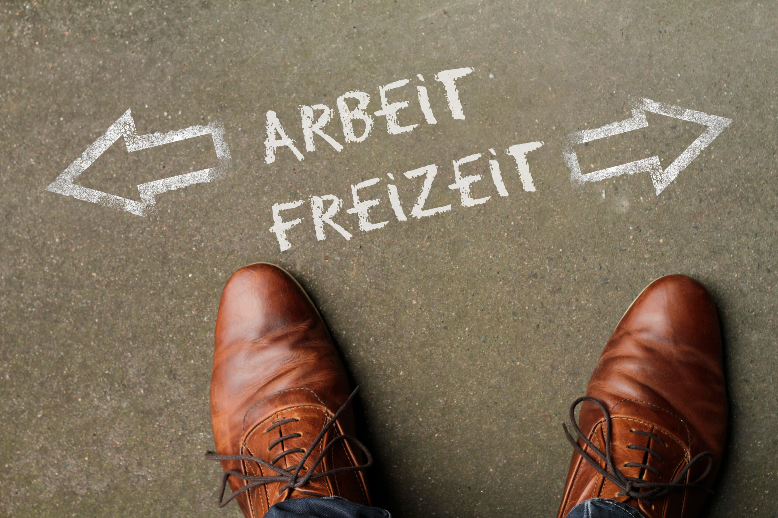Zwei Schuhe stehen vor den Wörtern Arbeit links, Freizeit rechts.