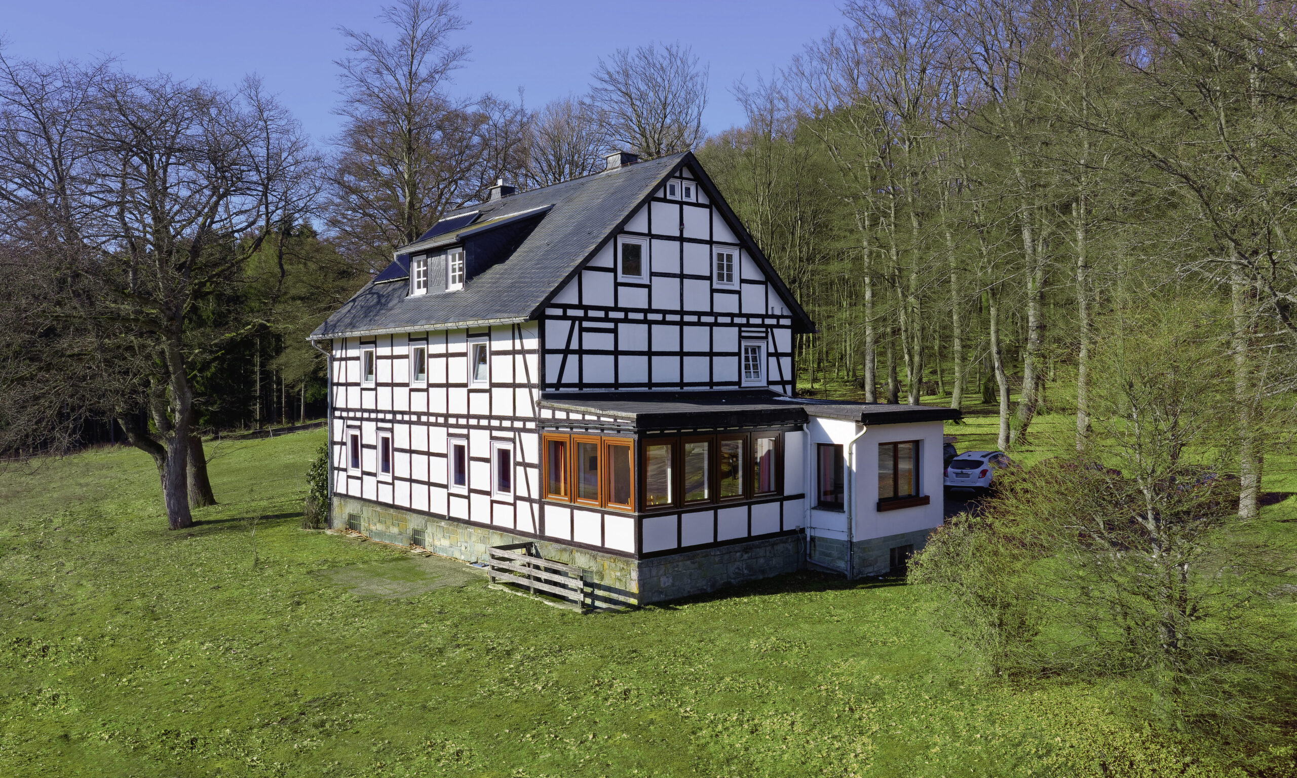 Fachwerkhaus in Alleinlage am Waldrand, umgeben von Wiesen und Bäumen in naturnaher Umgebung.