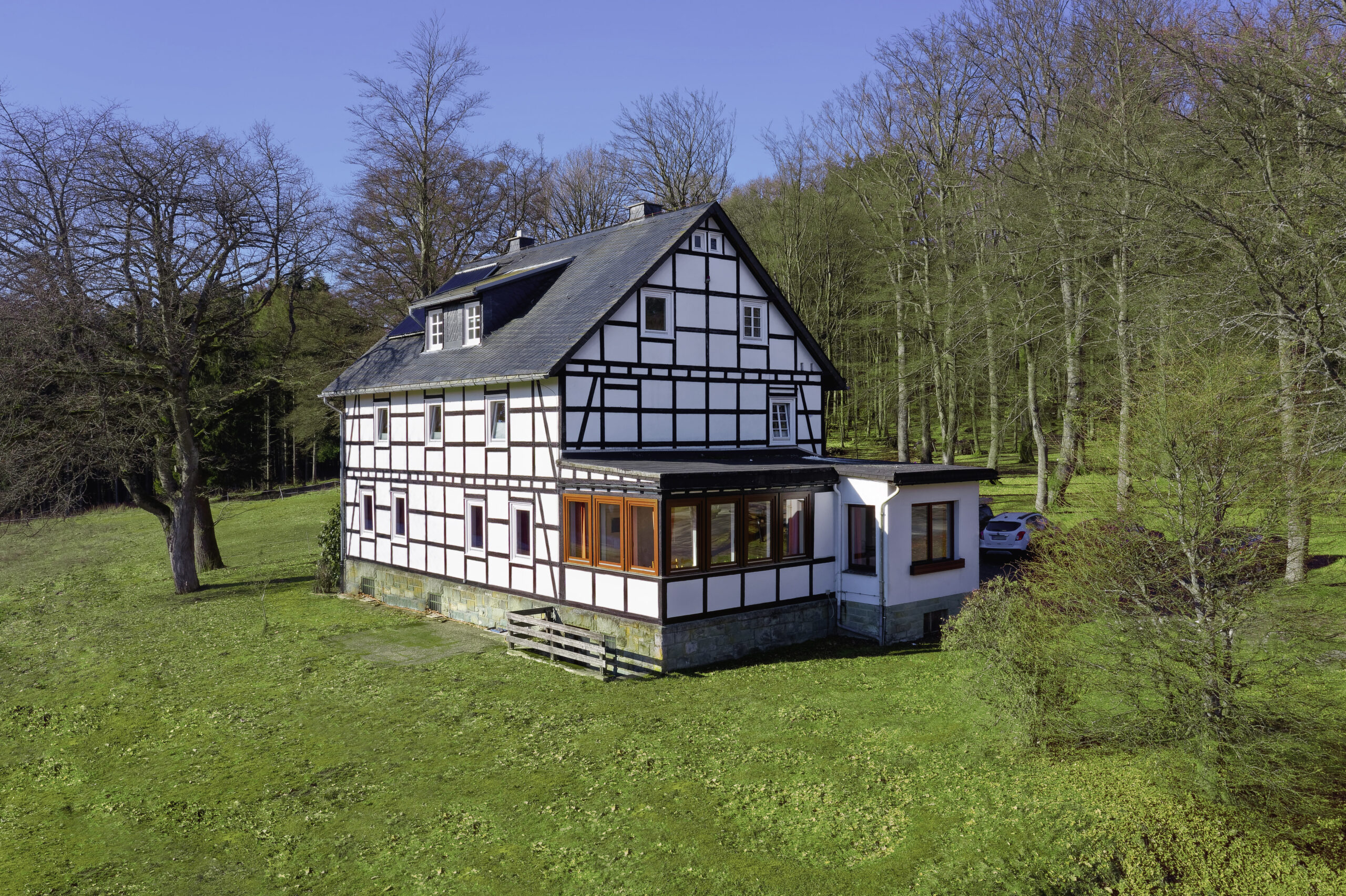 Fachwerkhaus in Alleinlage am Waldrand, umgeben von Wiesen und Bäumen in naturnaher Umgebung.