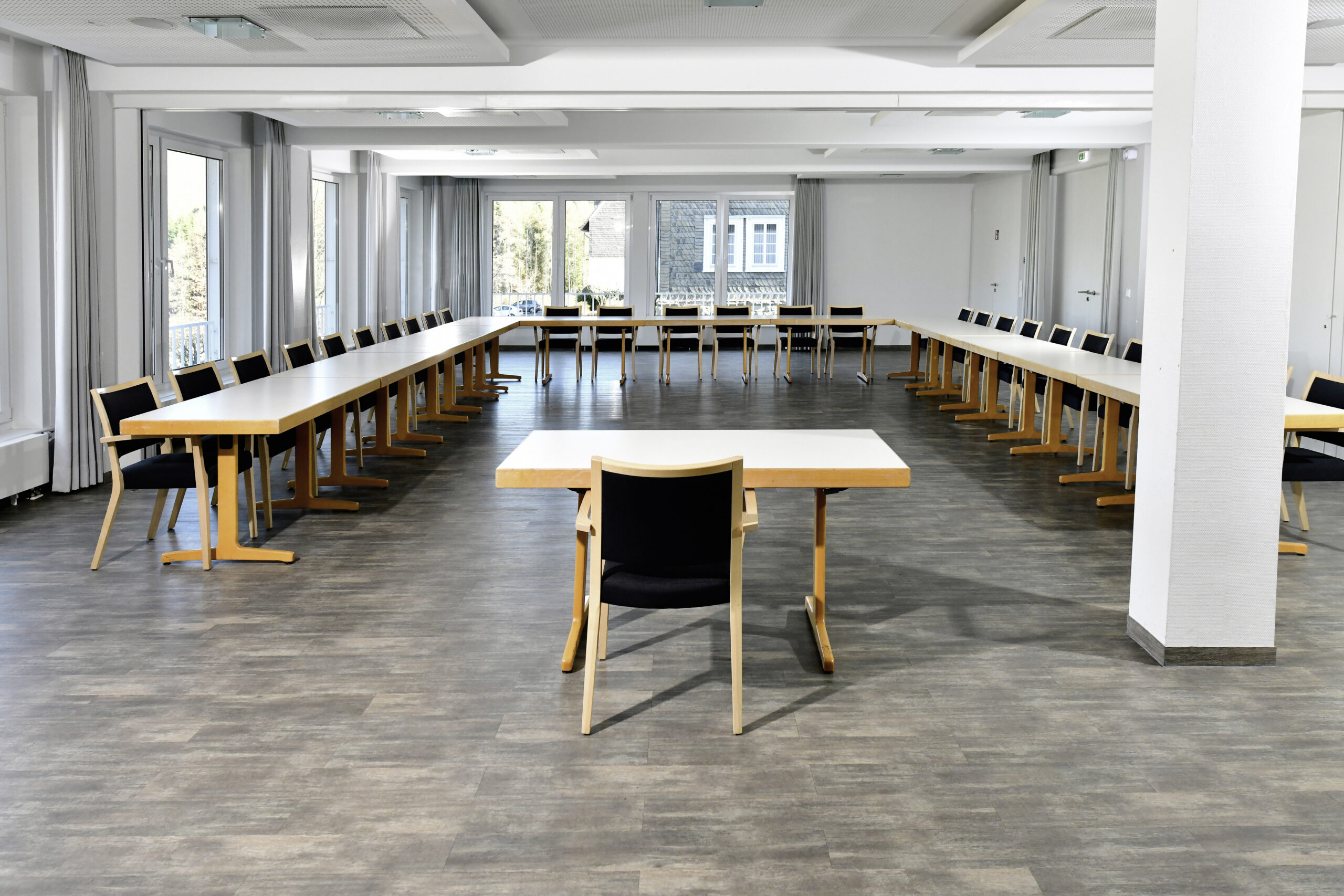 Großer, heller Seminar- und Tagungsraum mit U-förmig angeordneten Tischen für Gruppenarbeit und Besprechungen.