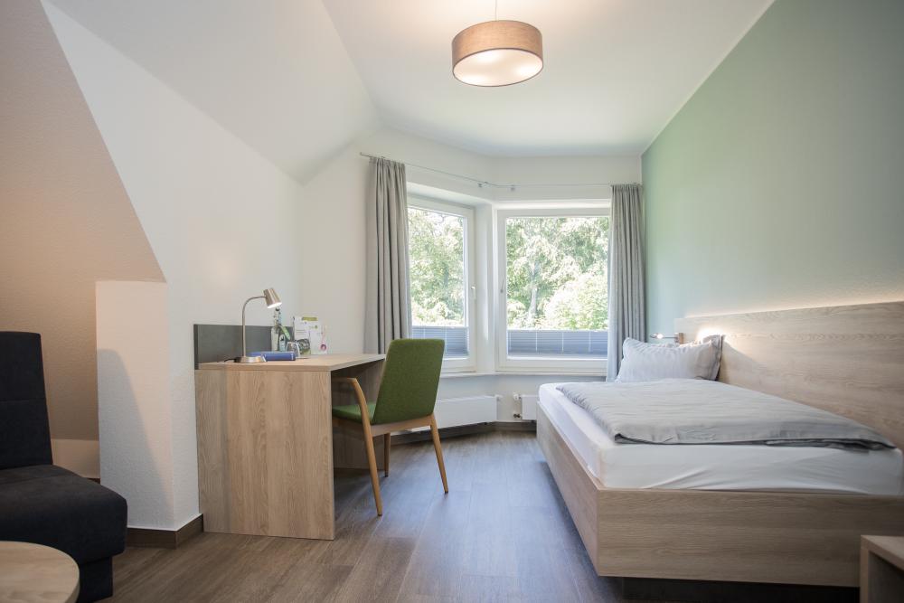 Hotelzimmer mit einem Bett, einem Schreibtisch und einem Stuhl