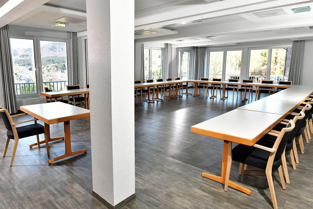 Heller Seminarraum als U-Form gestellt. Vorne ein Tisch für den Referenten.