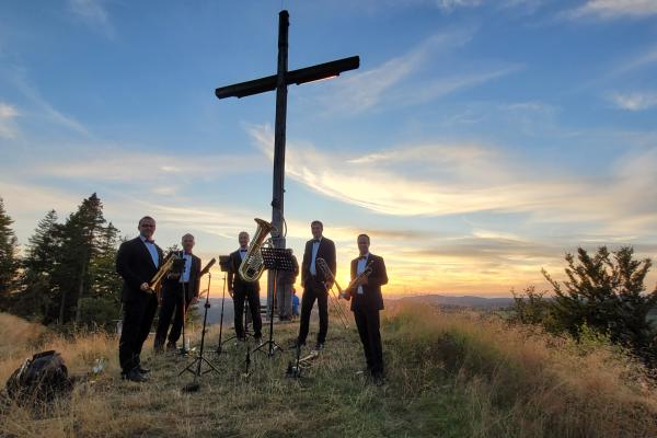 Kreuz auf einem Berg mit Mensch drum herum